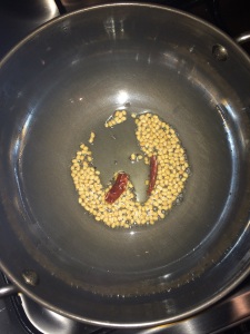 Allow the urad dal to brown and then add the red chilies.